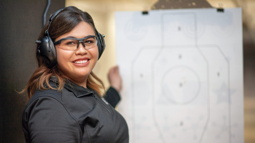 Woman standing in front of a target proudly